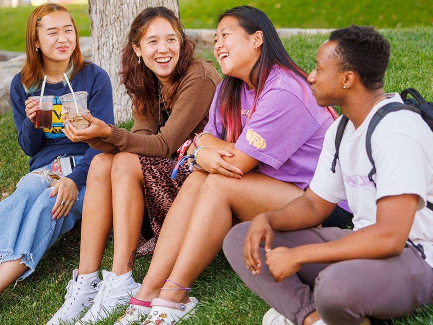 three students sitting next to the fountain